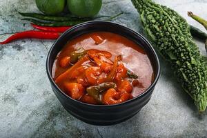 A bowl of chili and vegetables on a table photo