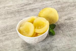 A bowl of peeled peaches and a lemon photo