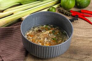 A bowl of soup with a spoon and some vegetables photo
