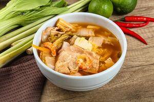A bowl of soup with meat, vegetables and other ingredients photo