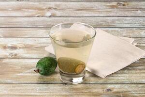 A glass of water and a green apple on a table photo