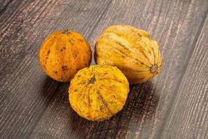 Three different types of squash on a wooden table photo