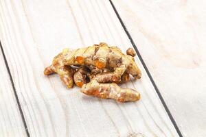 A pile of ginger root on a wooden table photo