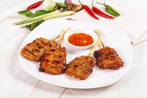 A plate of food with skewers and sauce photo