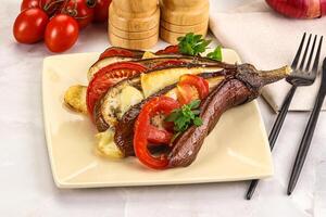 A plate with a steak, vegetables and a knife and fork photo