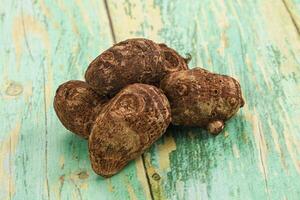 A pile of brown nuts on a wooden table photo