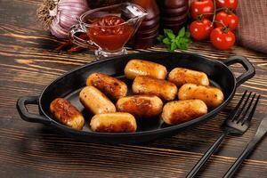 A pan with sausage rolls on a table photo