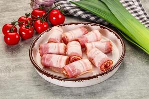 Bacon wrapped in bacon on a plate with tomatoes and onions photo