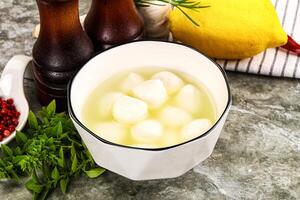 A bowl of lemonade with a lemon and a pepper photo