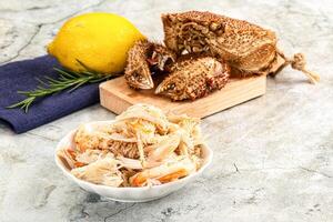A bowl of pasta with a lemon and a piece of fish photo