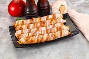A plate with bacon wrapped in cheese and tomatoes photo