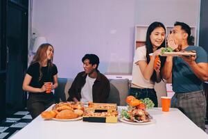 A group of people eating pizza and drinking beer photo