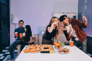 A group of people sitting around a table with pizza and drinks photo
