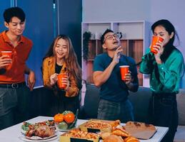 Four people standing around a table with food photo