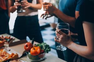 People toasting with wine and pizza at a party photo