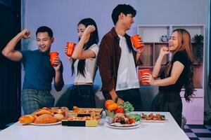 Four friends having fun with food and drinks photo