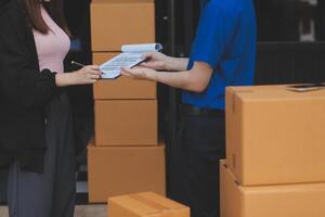 A man and woman are standing in front of a moving van photo
