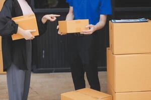 A man and woman are holding boxes and looking at each other photo