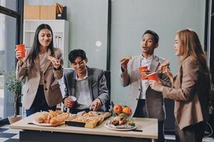 Group of business people eating pizza and drinking coffee photo