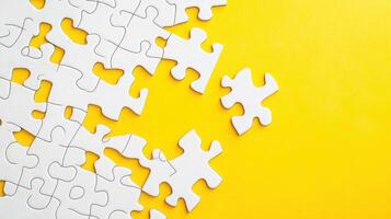 Puzzle pieces scattered on a bright yellow background with a single piece remaining to be placed, showcasing the challenge of completing the puzzle photo