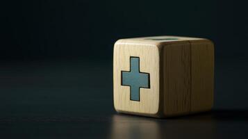 Wooden block with plus sign on a dark background symbolizes healing and medical care in a minimalist setting photo