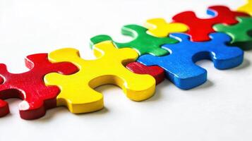 Colorful wooden puzzle pieces arranged in a line on a plain surface, demonstrating creativity and problem-solving skills in playtime activities for children photo