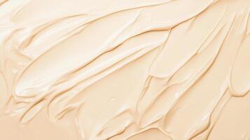 Creamy beige foundation spreads smoothly on a surface, showcasing its rich texture in a soft light environment during a makeup application photo