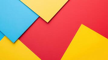 Colorful geometric patterns created with paper layers in vibrant shades of blue, yellow, and red placed on a flat surface photo