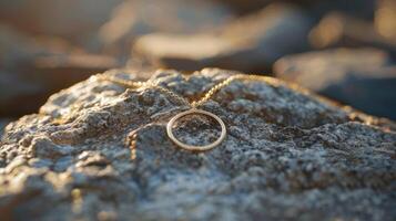 A gold necklace sits on top of a rock photo