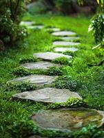 A stone path in a garden with grass and trees photo