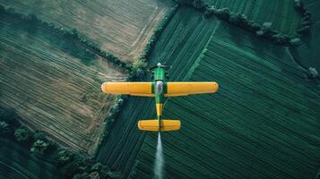 Aerial view of a small airplane spraying pesticide on a field photo
