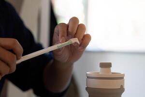 Sustainability and Eco-friendly Practices. A close-up of a person using a sustainable straw with the word Sustainable visible. photo
