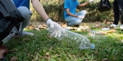 Waste Management and Eco-Friendly Solutions. Focused volunteer picking up plastic waste in a park, contributing to a greener planet. photo