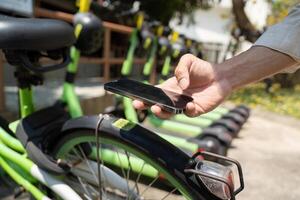 Digital Engagement and Smart Mobility. A person scanning their mobile device to access bike-sharing services, enhancing urban transportation. photo