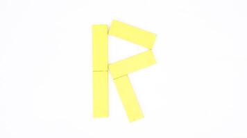 Letter R from yellow color wood block isolated on white background photo