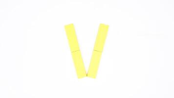 Letter V from yellow color wood block isolated on white background photo