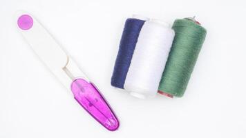 Sewing thread reels and tool isolated on white background photo