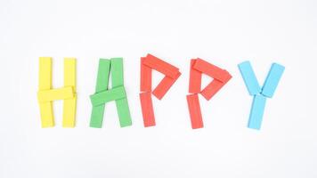 HAPPY word formed using wooden blocks of board game isolated on white background photo