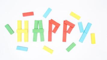 Selective focus of HAPPY spelled with wooden blocks of board game isolated on white background photo