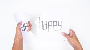 Close up of hands tearing letters UN from word UNHAPPY to get HAPPY isolated on white background photo