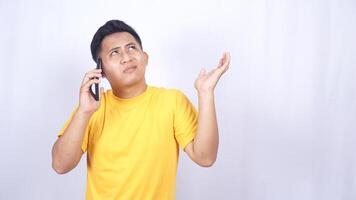 Confused Asian man while doing phone call isolated on white background photo