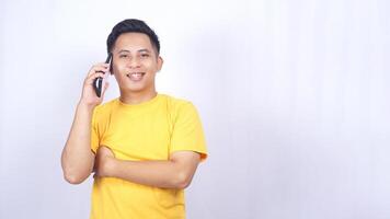 Smiling Asian man doing phone call with casual gesture isolated on white background photo