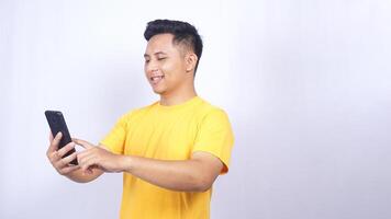 Portrait of Happy Asian man scrolling through mobile phone screen isolated on white background photo