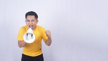 Excited Asian man shouting on megaphone isolated on white background photo