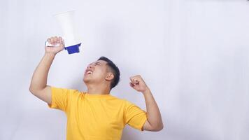 Asian man shouting through megaphone excitedly isolated on white background photo