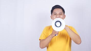 Happy Asian man shouting on megaphone isolated on white background photo