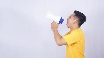 Side view of Young Asian man shouting on megaphone isolated on white background photo