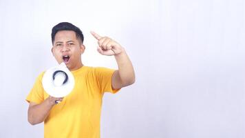 Angry Asian man shouting on megaphone and doing demonstration isolated on white background photo