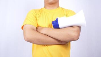 Close up of man crossing his arms while holding megaphone isolated on white background photo