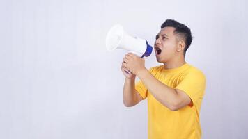 Young Asian man shouting on megaphone isolated on white background photo